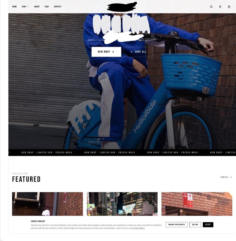 Person in blue clothing with white graphics sitting on blue Citibike bicycle against brick wall
